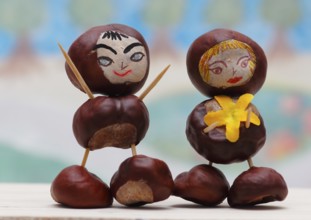 Two cute chestnut figures in front of a painted background, North Rhine-Westphalia, Germany, Europe