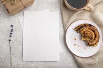 White paper invitation card, mockup with lavender, bun, cup of coffee, linen textile, box on gray