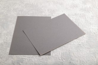 Gray paper business card, mockup on gray concrete background. Blank, flat lay, top view, still