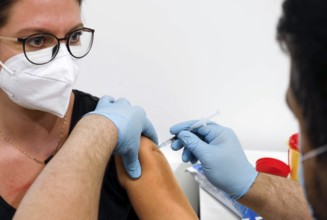 A woman receives a booster vaccination from Moderna against Covid 19 at the Schönefeld vaccination