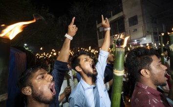 Members of the All Assam Students' Union (AASU) take part in a flaming torch rally and shout