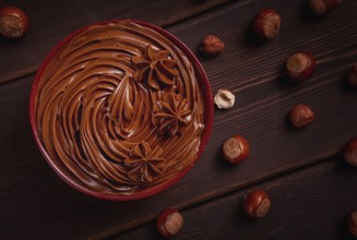 Chocolate nut paste, mousse, pasta, in a cup, on a wooden table, top view, selective focus, no