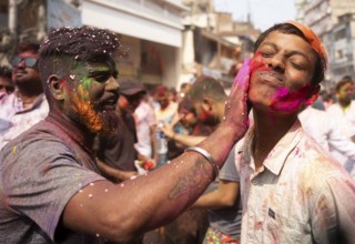 People smear colours eachother as they celebrate Holi on a street, the Hindu spring festival of