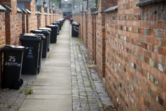 Back alley with rubbish bins. The Railway Village built by GWR to house workers in the 1840s,