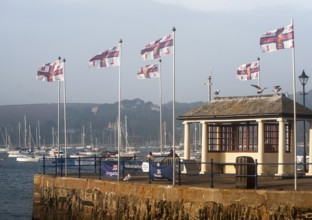 RNLI flags flying in the breeze on Prince of Wales pier, Falmouth, Cornwall, England, UK