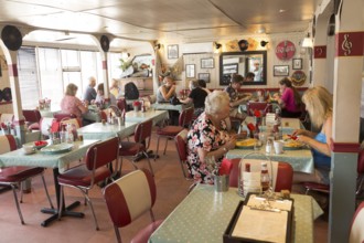 People eating inside the Ferry Cafe, Felixstowe Ferry, Suffolk, England, UK