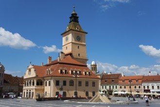 Market square on a sunny day with historic building with tower clock and relaxed people, Old town