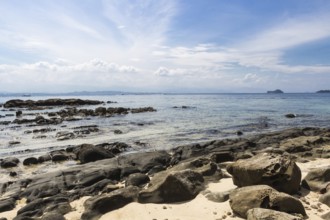 Sandy tropical beach with big gray stones