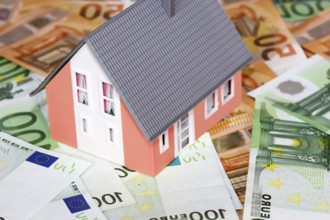 Concept photo with model house, euro notes and coins