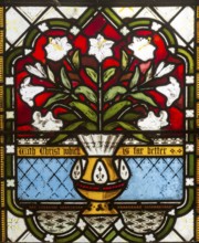 Memorial stained glass window of vase and lily flowers, in village parish church, Saint John the