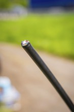 Close-up of a black cable with blurred green background, fibre optic installation, Calw district,