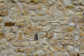 Natural stone wall with a mixture of beige and grey bricks, sandstone wall, background, texture,