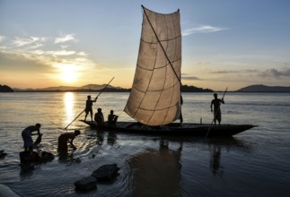 Fishermen paddle down the Brahmaputra River after fish in Guwahati, Assam, India on August 25, 2019