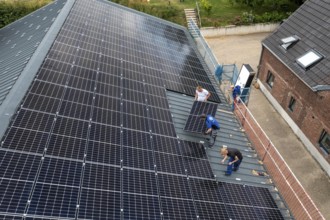 Installation of solar modules on the roof of a barn on a farm, over 210 photovoltaic modules are