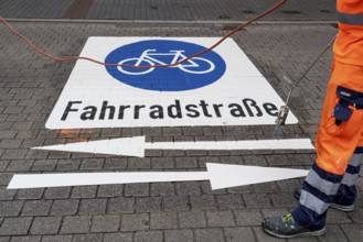 Application of road markings for a cycle lane, Rüttenscheider Straße in Essen, in the shopping and