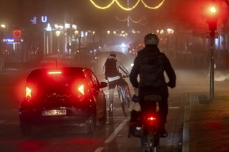 Cyclist, darkness, inner city traffic, Rüttenscheider Straße, bicycle lane, fog, autumn, winter,