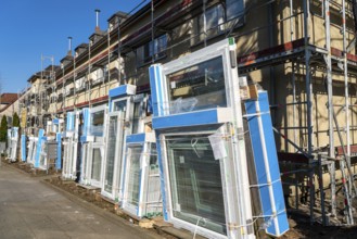 Energy-efficient refurbishment of residential buildings, older apartment block is scaffolded, gets