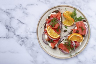 Sandwich with freshly smoked salmon, on black bread, with cottage cheese, with herbs and red