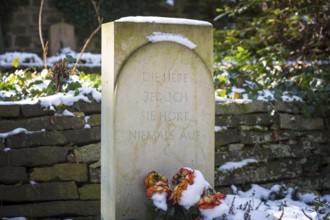 Gravestone with snow and frozen roses, inscription Die Liebe jedoch sie hört niemals auf, Dresden