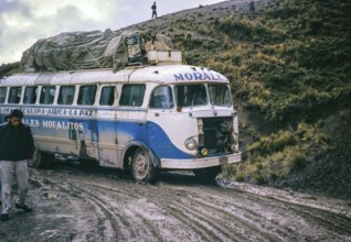 Passengers walk as Morales Mofalito's bus to La Paz slips in the mud on a difficult stretch of