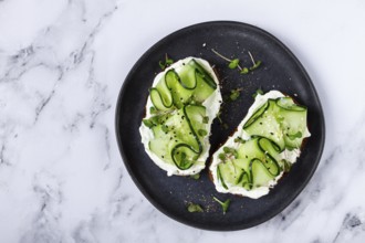 Breakfast, grain bread sandwiches, cream cheese, sliced cucumber, with microgreens, and sesame