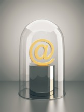 A golden email sign under a glass dome