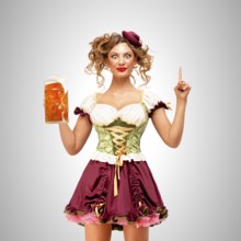 Beautiful Oktoberfest waitress wearing a traditional Bavarian dirndl dress holding a beer mug, and