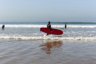 People surfing in Atlantic Ocean on beach, Taghazout, Morocco, North Africa, Africa