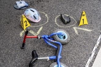 Markings at an accident scene with a balance bike for children, helmet, reenacted accident