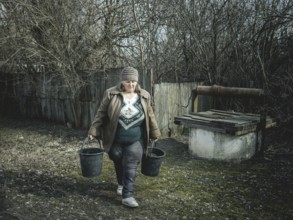 Larisa draws water from a well in Borshchivka. The village was under Russian occupation. She hid