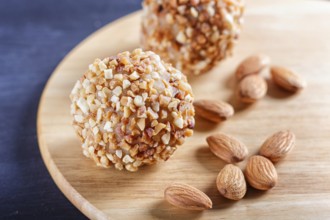 Energy balls cakes with almonds on wooden board on black background. selective focus, close up