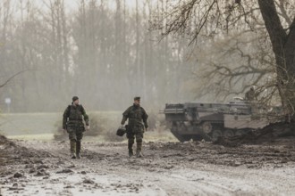 Two soldiers walking on a muddy path, taken as part of the military exercise 'Wettiner Schwert'