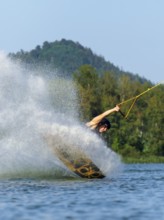 Heavy landing with wakeboard in the lake, water splashes, water sports, water skiing in the