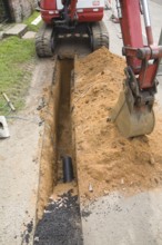 Digging a trench to take electricity supply cables underground, Shottisham, Suffolk, England,