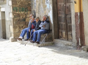 Men sitting together on stone bench, Garganta la Olla, La Vera, Extremadura, Spain, Europe