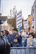 Demonstrators with signs showing political messages behind barriers, demonstration against the