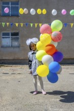 Happy schoolgirl with colourful balloons on the first day of school, Issyk-Kul region, Kyrgyzstan,