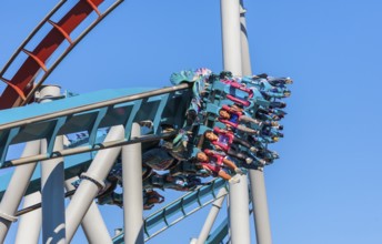 Theme park guests riding Dragon Challenge roller coaster in Wizarding World of Harry Potter at