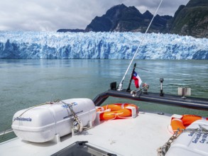 Tourists visiting the San Rafael glacier lagoon, view from excursion boat towards glacier front,