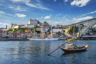 View of Porto city and Douro river with traditional boats with port wine barrels and sailing ship