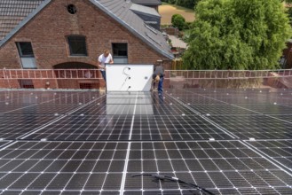 Installation of solar modules on the roof of a barn on a farm, over 210 photovoltaic modules are