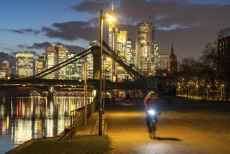 Skyline of the city centre of Frankfurt am Main, cyclist with light on the cycle path, pavement,