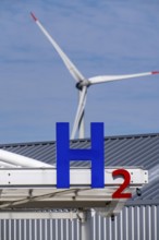 Hydrogen filling station in Antwerp, for cars and lorries, H2 lettering, wind turbine in the