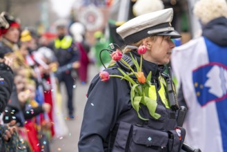 Rose Monday parade in Düsseldorf, policemen on duty at the street carnival, with flower