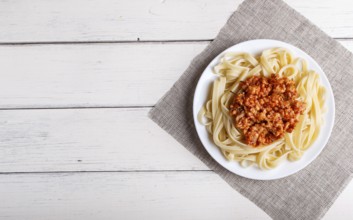 Fettuccine bolognese pasta with minced meat on white wooden background. top view, copy space