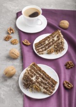 Homemade cake with milk cream and walnuts with cup of coffee on a gray concrete background and