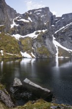 Lake Reinevatnet is located on the Reinebringen mountain. Rock faces with remnants of snow in early