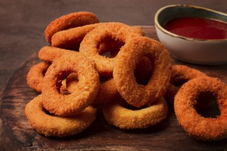 Crispy chicken rings, fried, on a wooden board, close-up