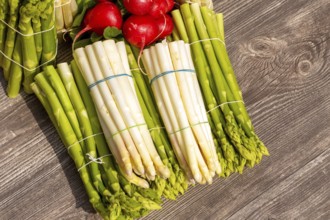 Green asparagus and white asparagus decorated on a rustic wooden table