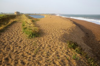 North Sea coastline view of shingle ridge and lagoon on beach bar, Shingle Street, East Lane,